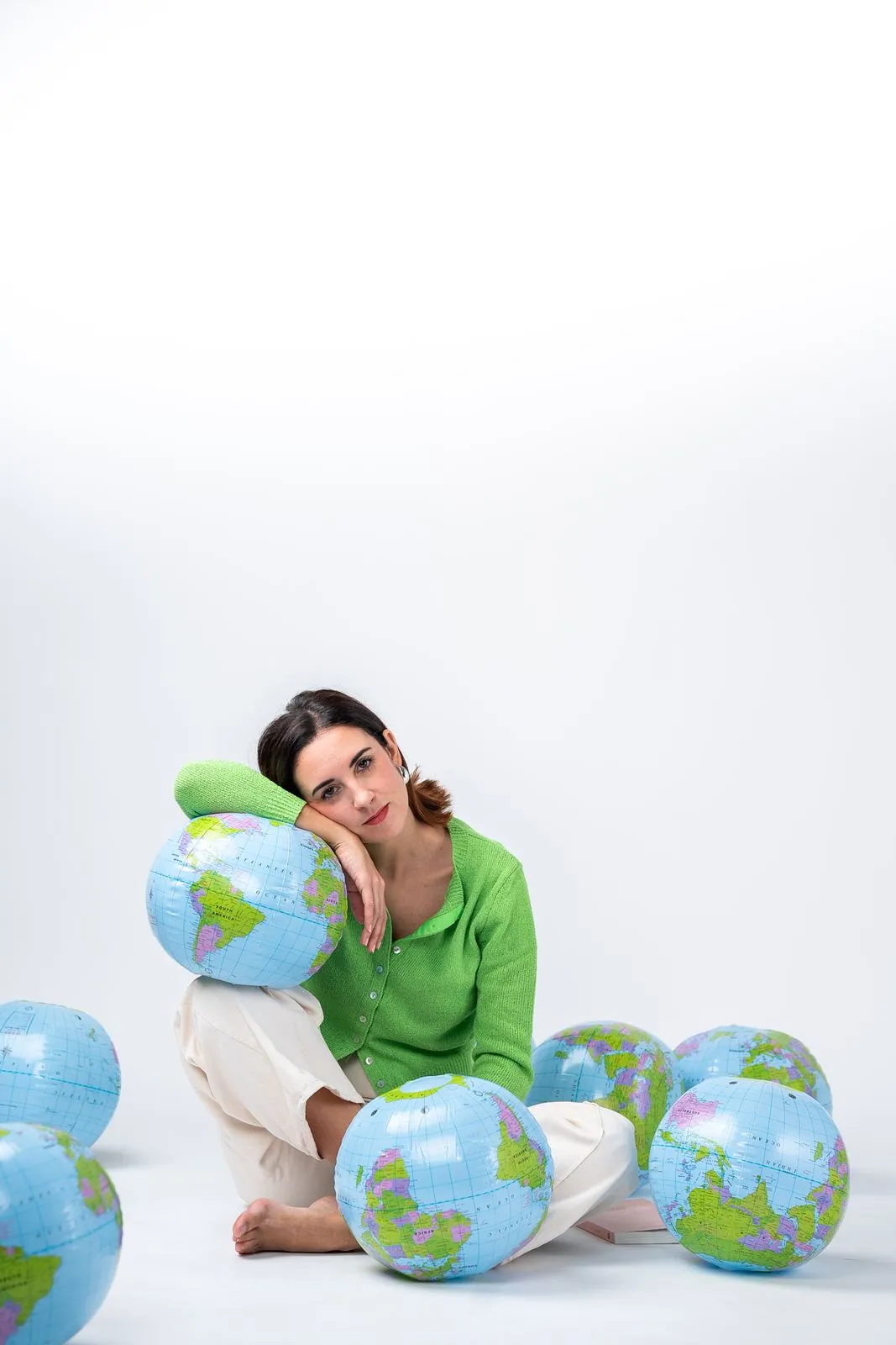 Retrato de escritora abrazada a globos terráqueos