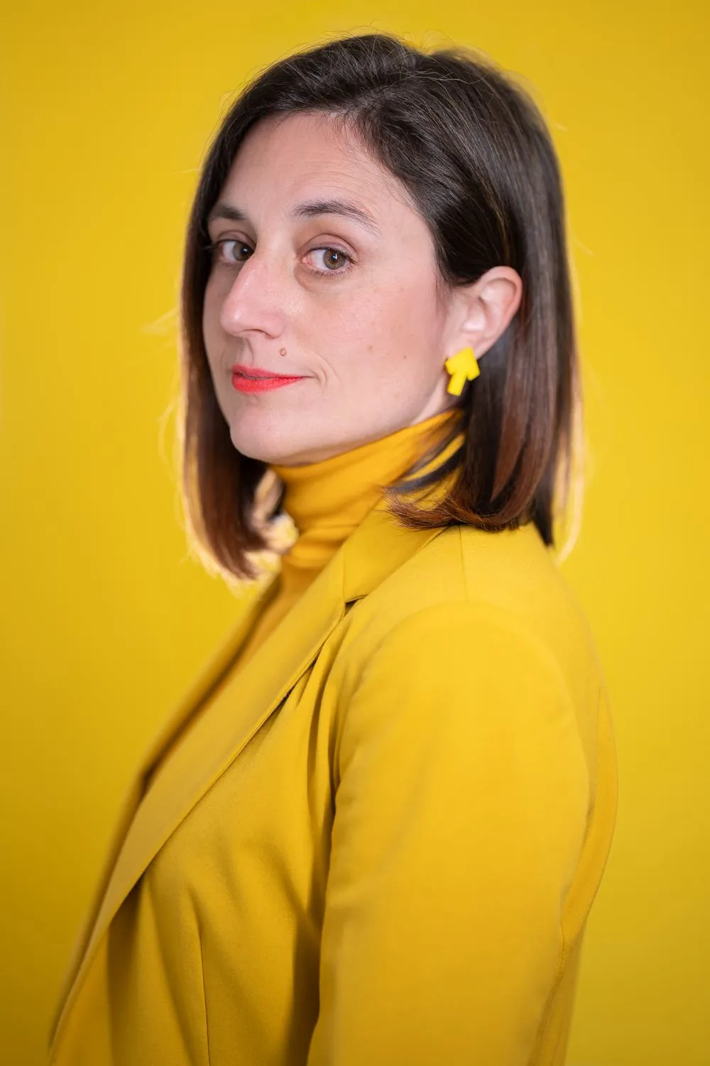 Retrato de Judith Antolín sobre fondo amarillo