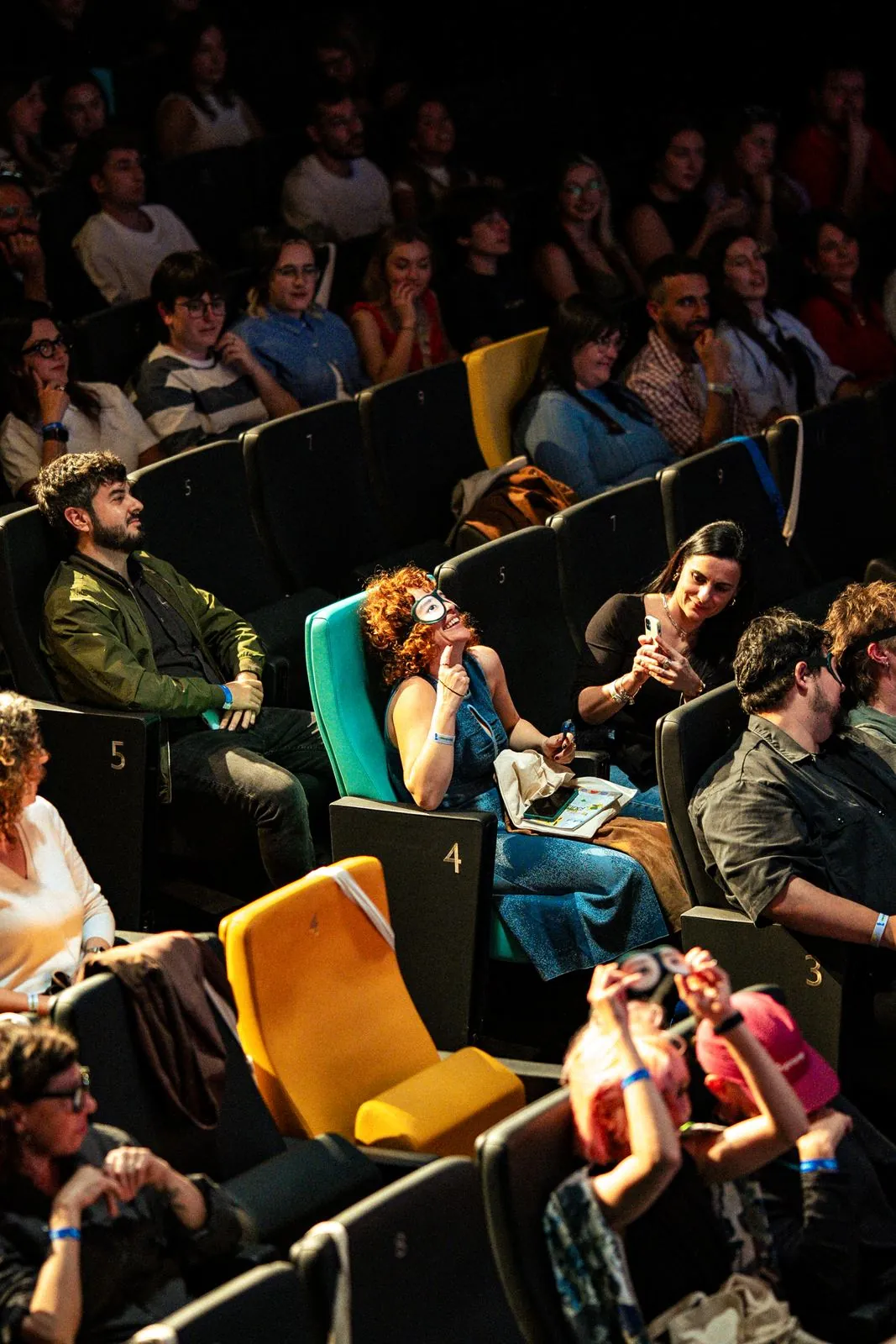 Público con butacas de colores en un auditorio