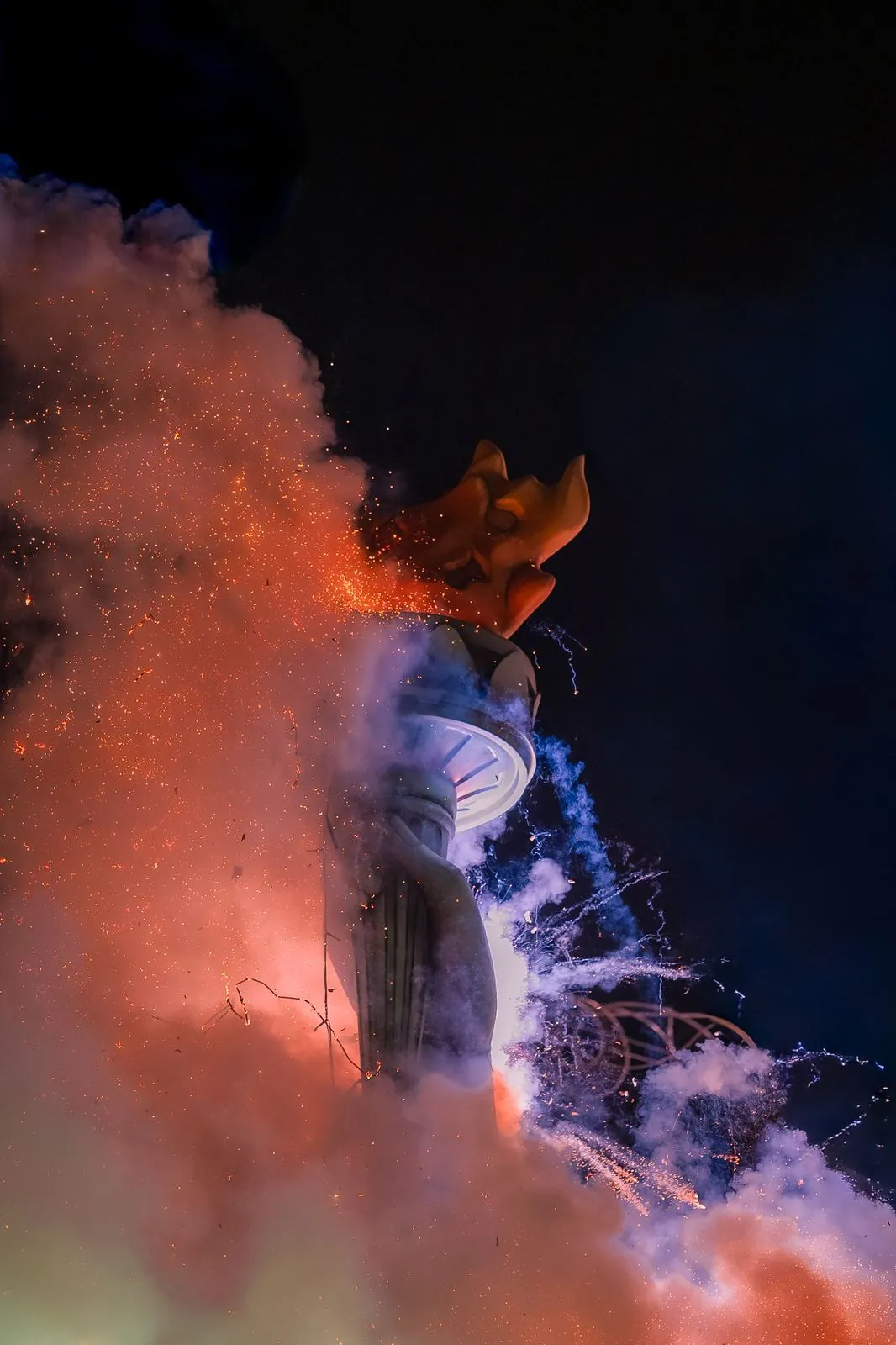 Humo naranja y chispas en una mascletà
