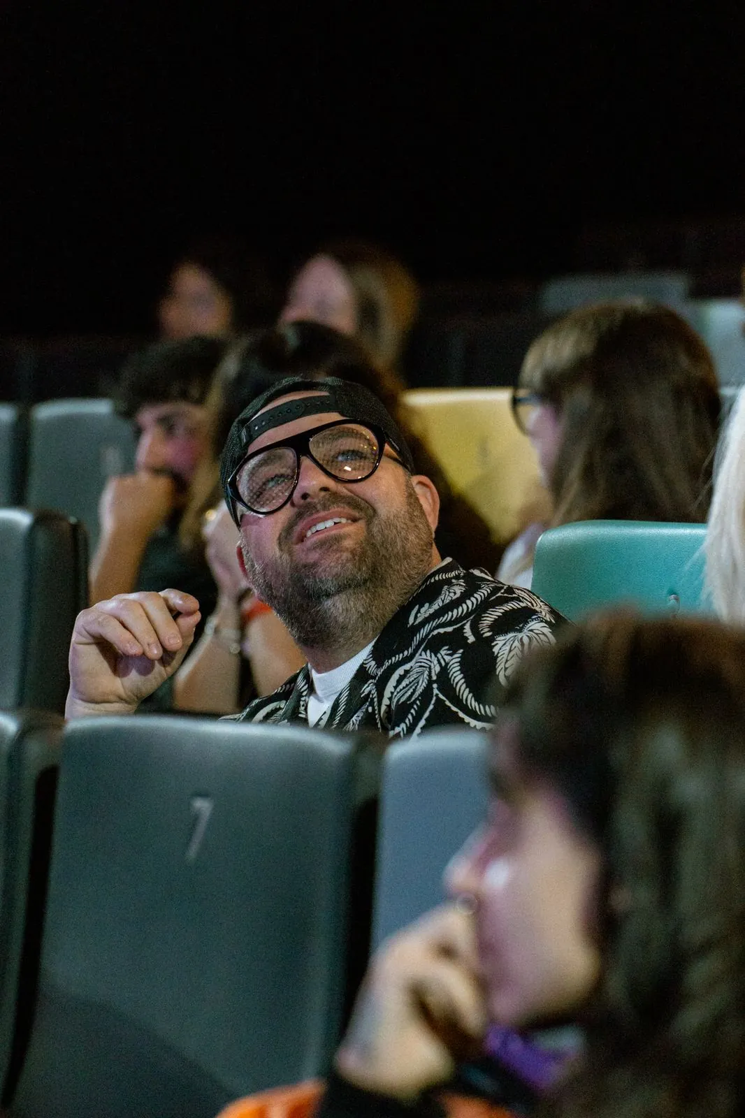 Asistente sonriente con gafas en la platea